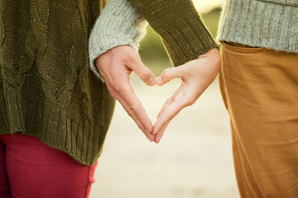 couple making a heart shape with their hands